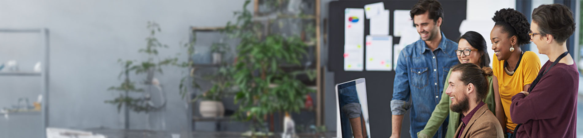 Diverse group of people looking at a computer monitor