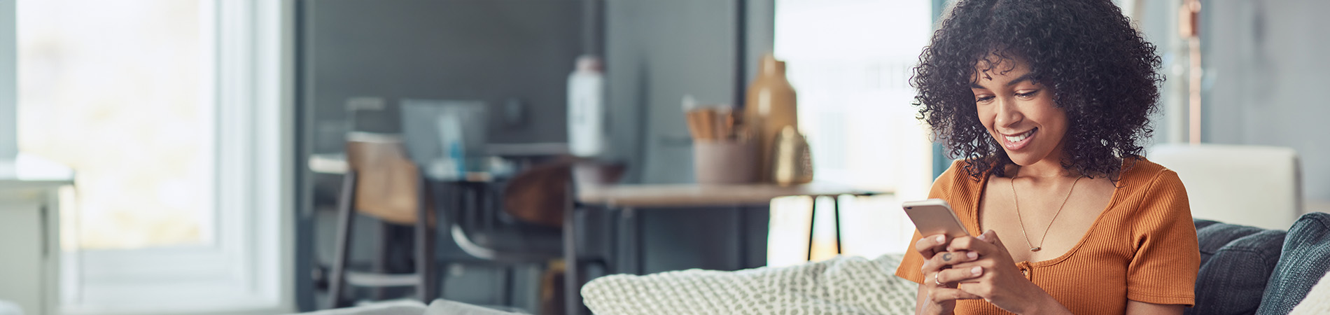 smiling woman using mobile device at home