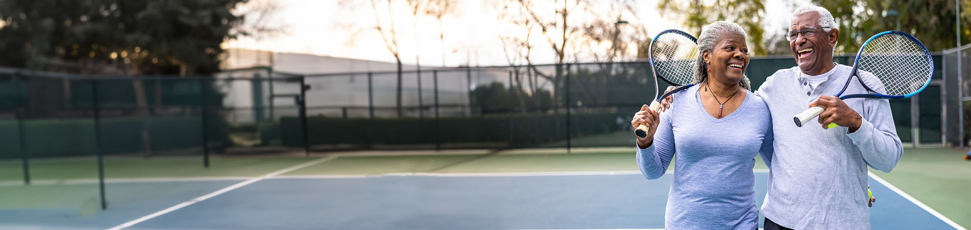 Couple on tennis court holding tennis rackets