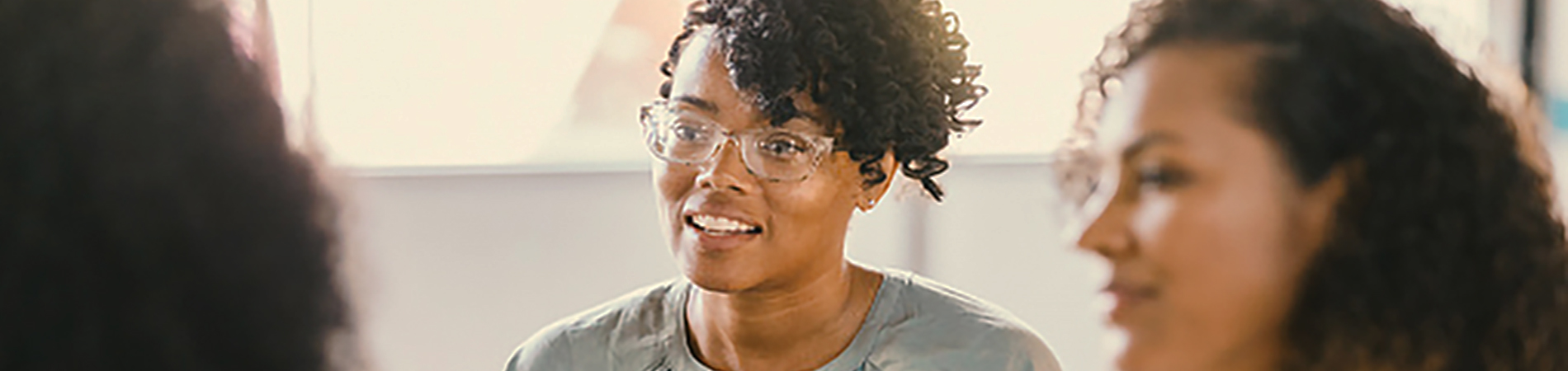 During group therapy, two women listen attentively as a third, unrecognizable woman speaks.